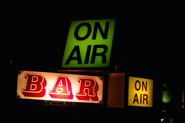 lighted neon sign sitting above a bar