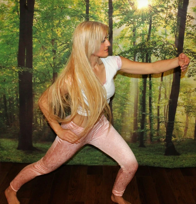 the blonde haired woman is doing yoga in a pink outfit