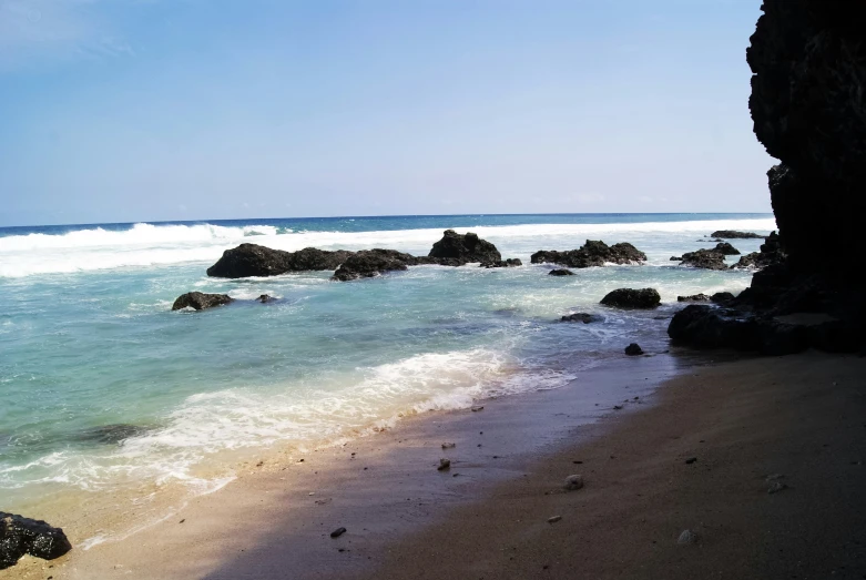 a beach with a small amount of ocean and water