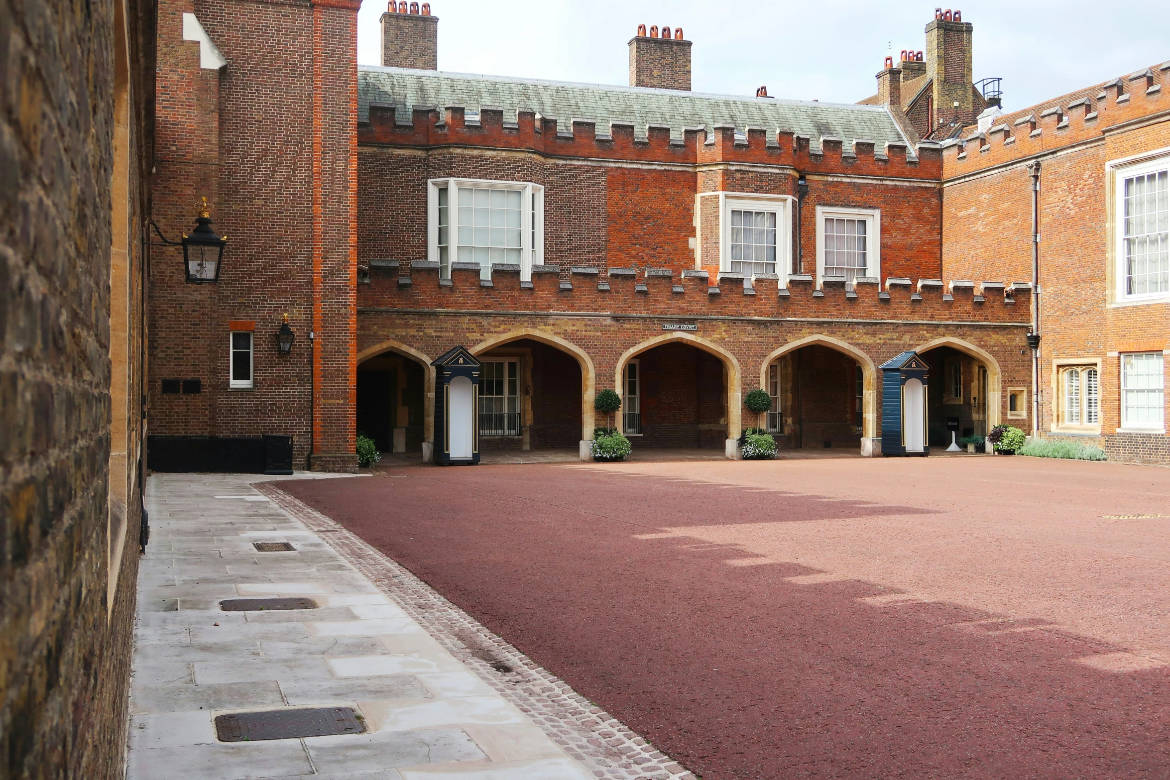 a courtyard with brick buildings and windows on each side of it