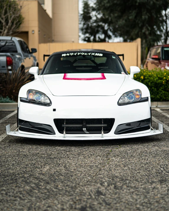 a white sports car parked in a lot