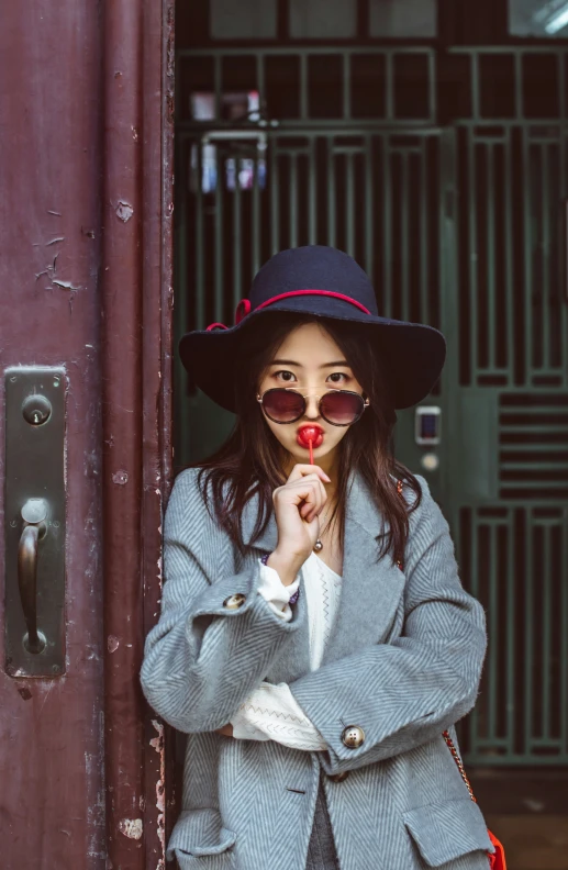 a woman is wearing a gray suit and red lipstick