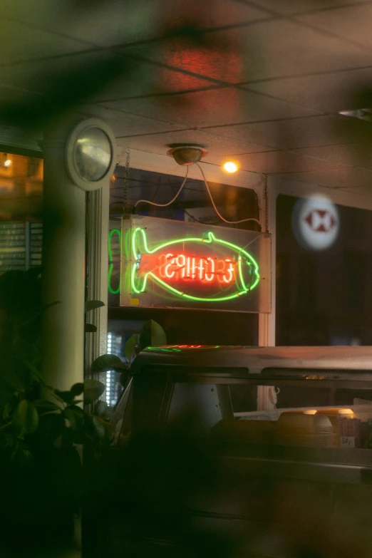 a fish neon sign is lit up on a bar