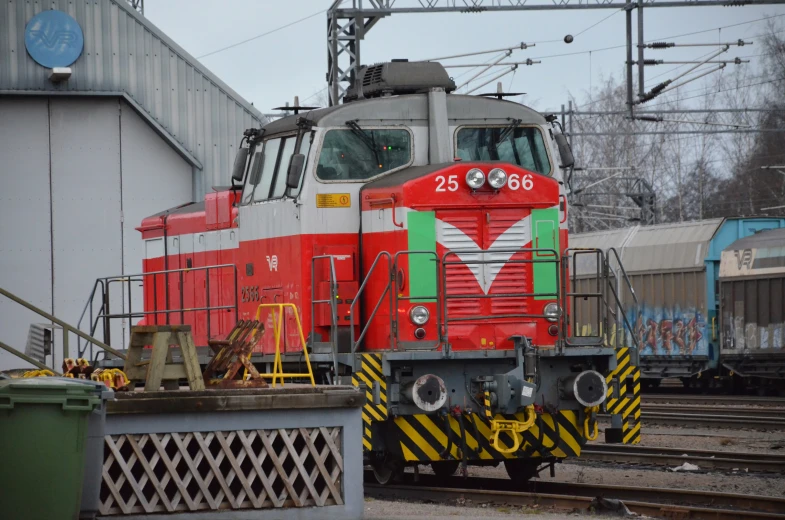 red and silver train next to some steel tracks