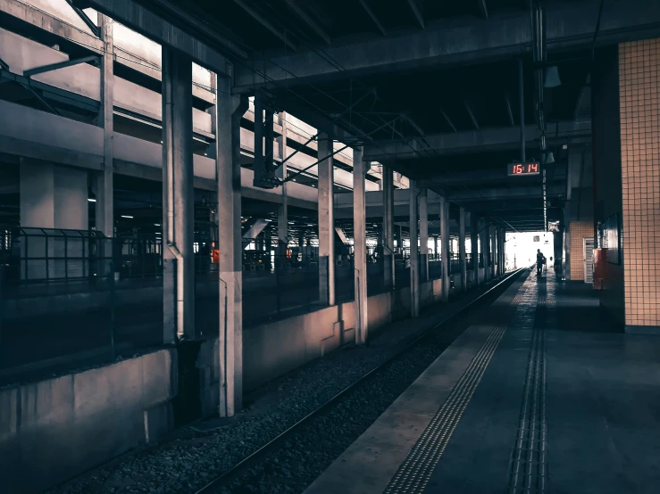 a lone person standing on the platform near a train