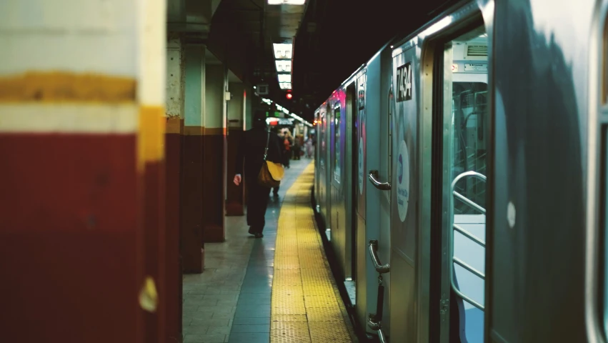 a train sitting at a station with people loading onto it