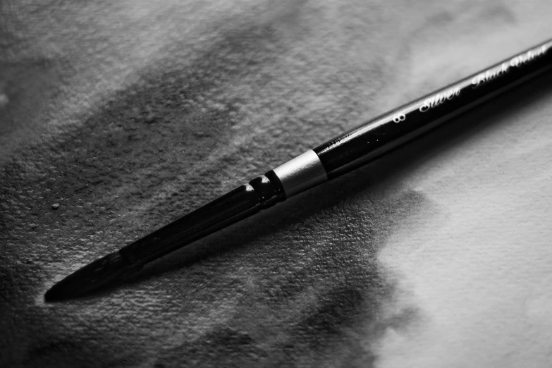 a black and white pen sitting on a piece of paper