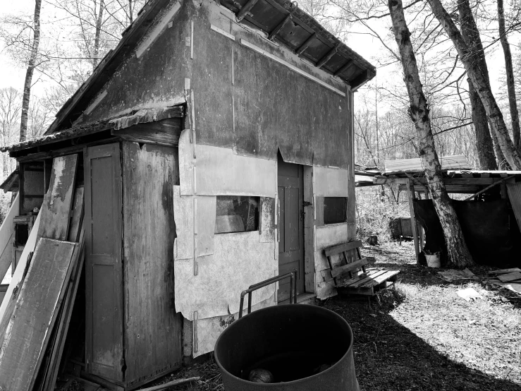 a black and white pograph of a building with a bucket outside