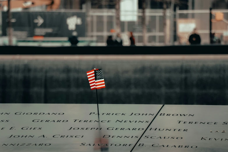 a us flag is placed at the base of the inscription of death