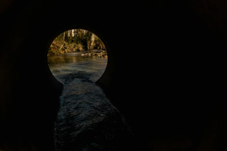 a river is flowing through the dark tunnel