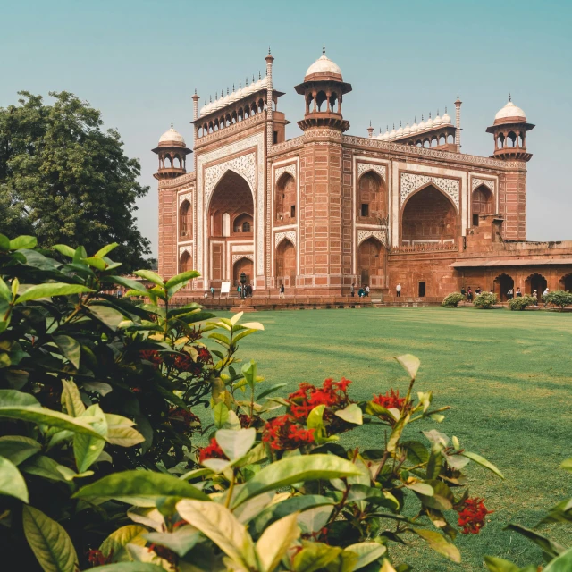 the white and brown building with four minage towers is surrounded by lush greenery