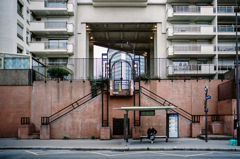 a brick wall has a tall building and a balcony