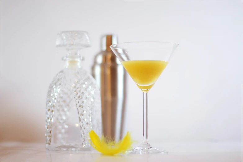 a glass of beverage sitting next to a bottle