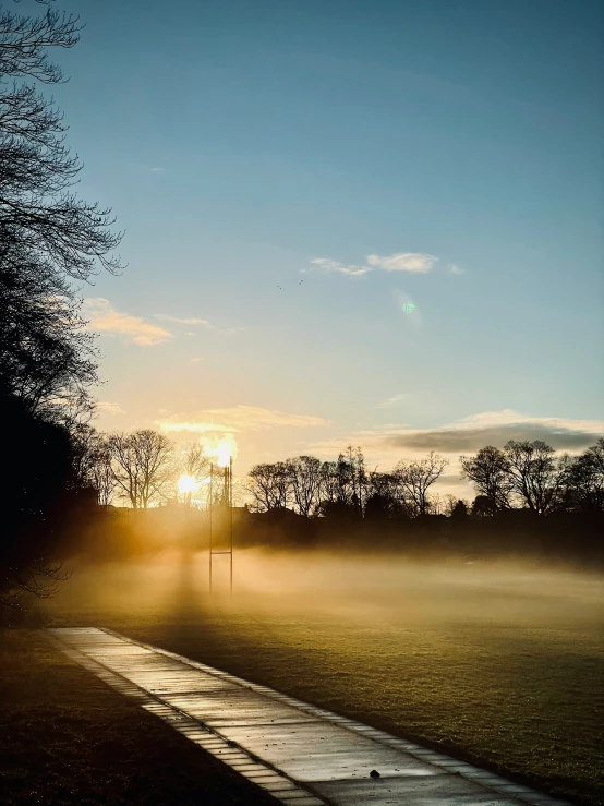 a bench sitting in the middle of a park covered in fog