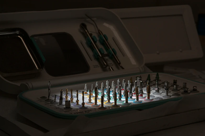 a collection of surgical instruments sit inside a white case