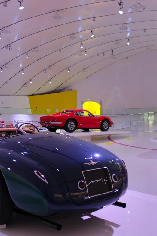 a car on display in a museum filled with other cars