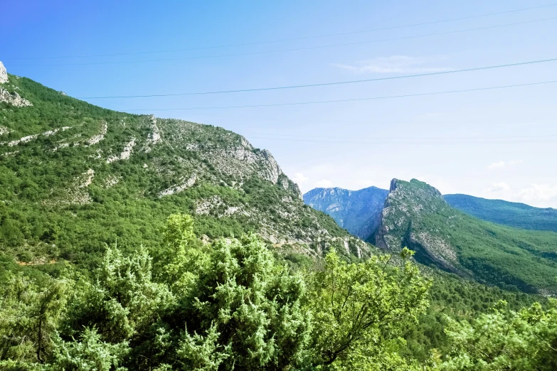 a big green mountain sitting over trees and hill