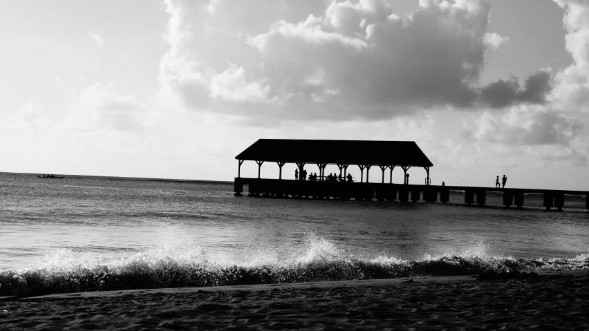 a house with a pier on the side of the ocean