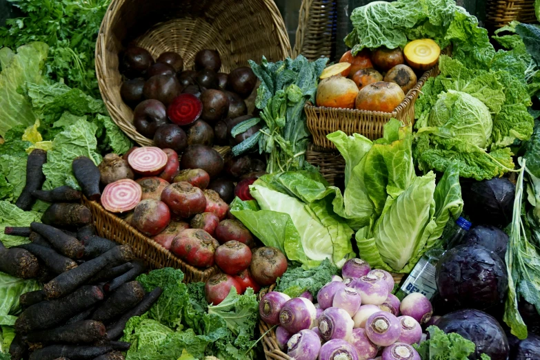 a pile of fresh produce, including eggplant, onions and turnips