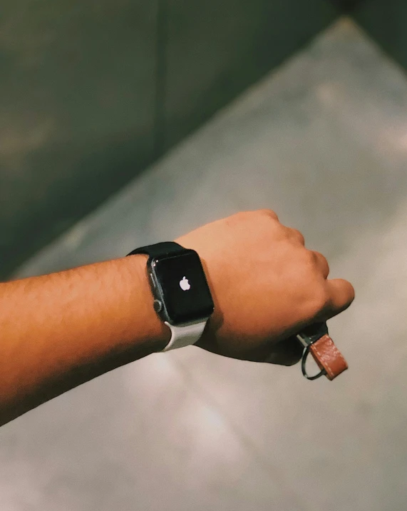 the arm and wrist of someone with an apple watch on their sleeve