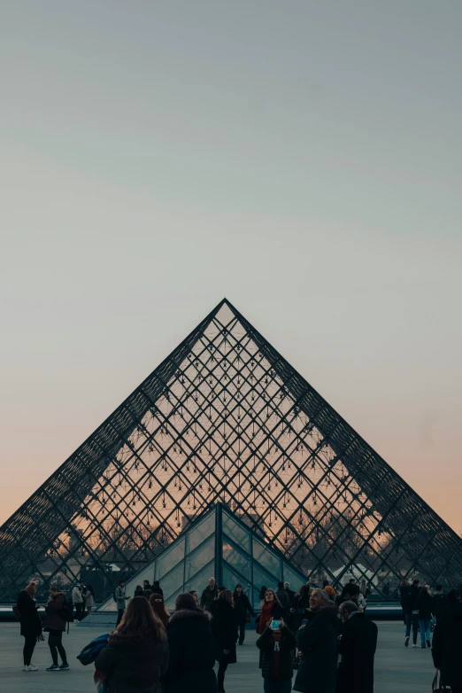 a large pyramid with people in it and sunset