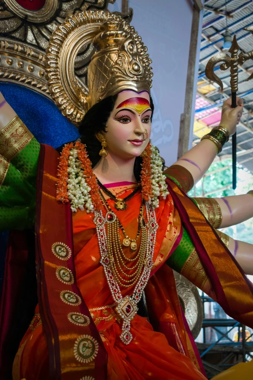 statue of a woman with multiple outfits, holding an intricate object