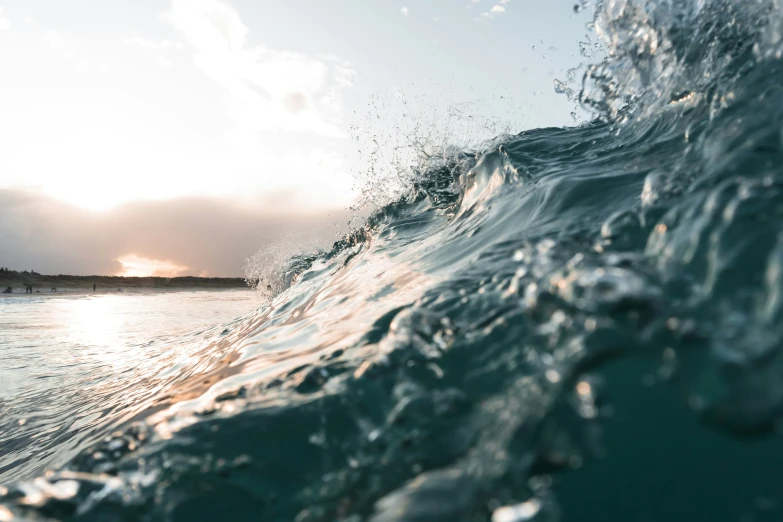 a wave of water splashes towards the sun