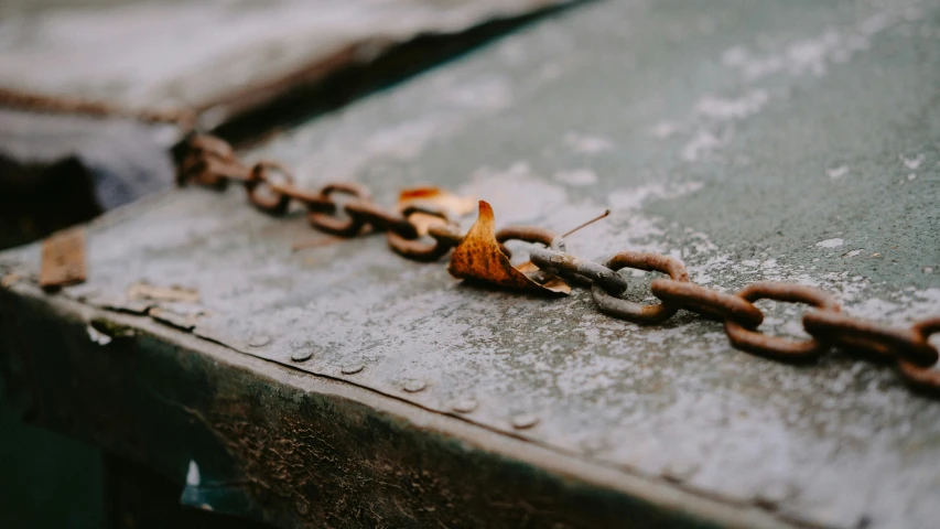 rusted metal chains are connected to concrete