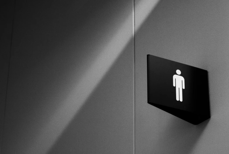 a black restroom sign on the wall