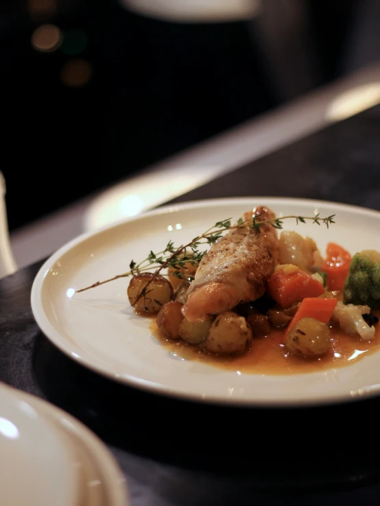 a plate with fish and veggies sits on the table