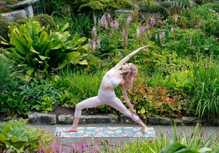 woman doing yoga in front of various vegetation