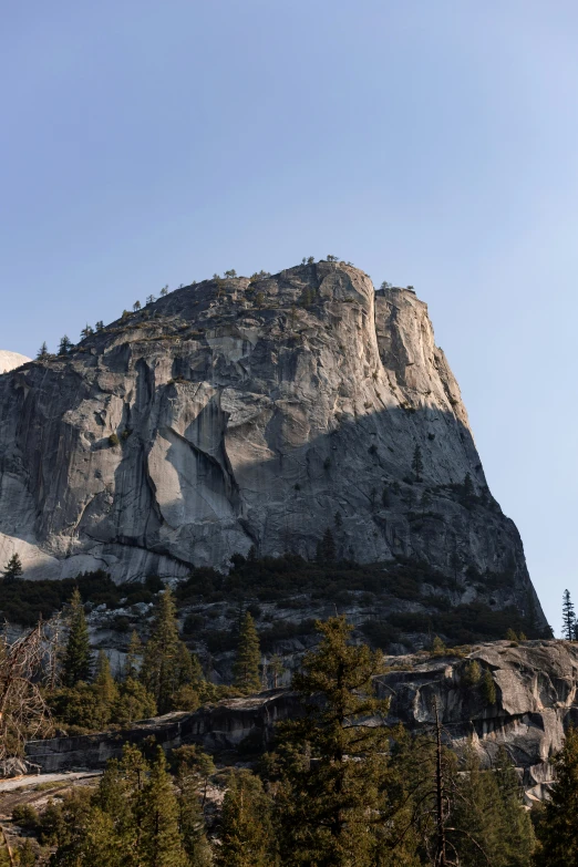 a mountain is surrounded by pine trees