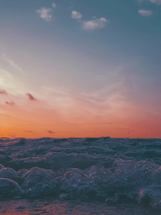 a person surfing on waves at sunset