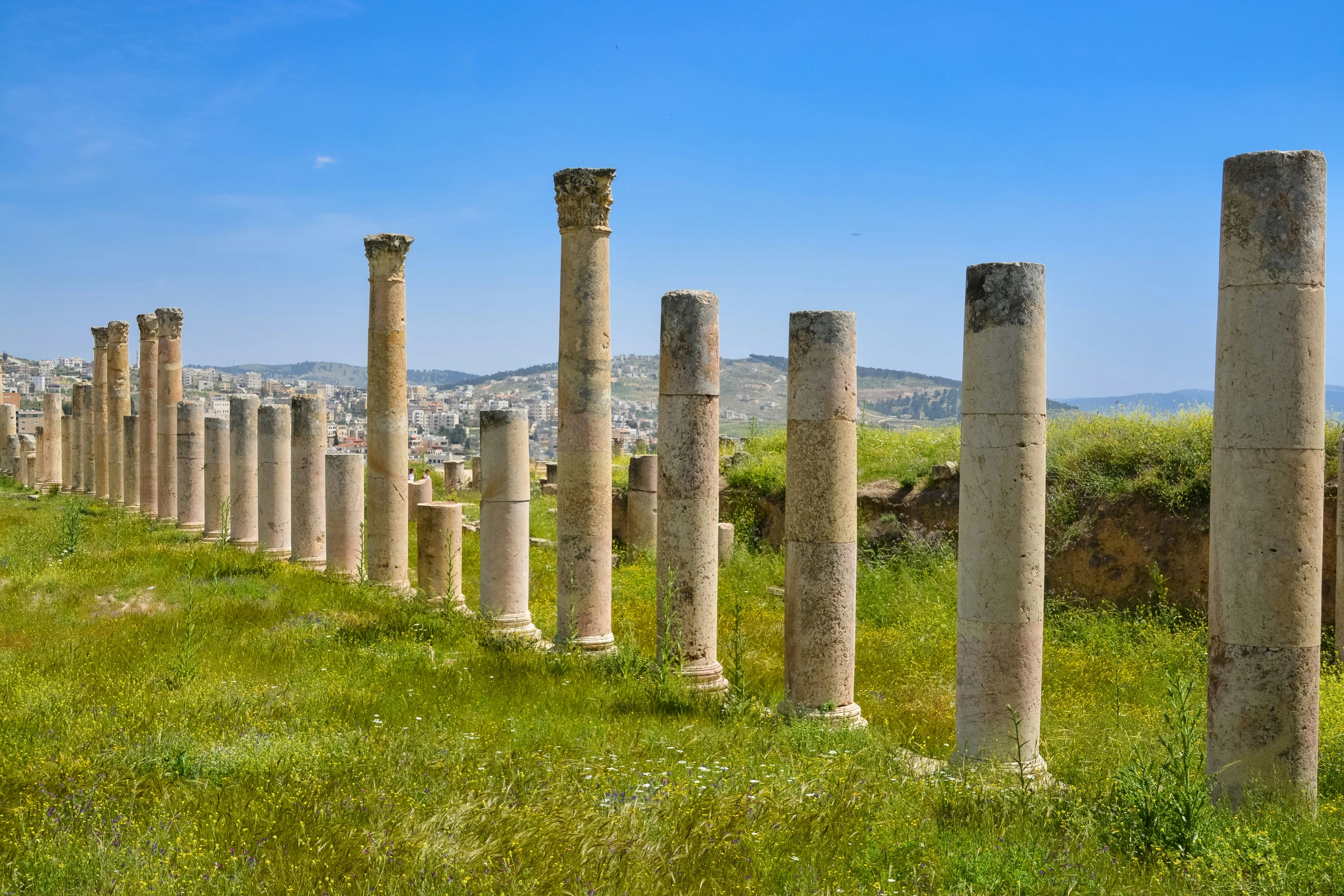 rows of stone pillar near a green grass field