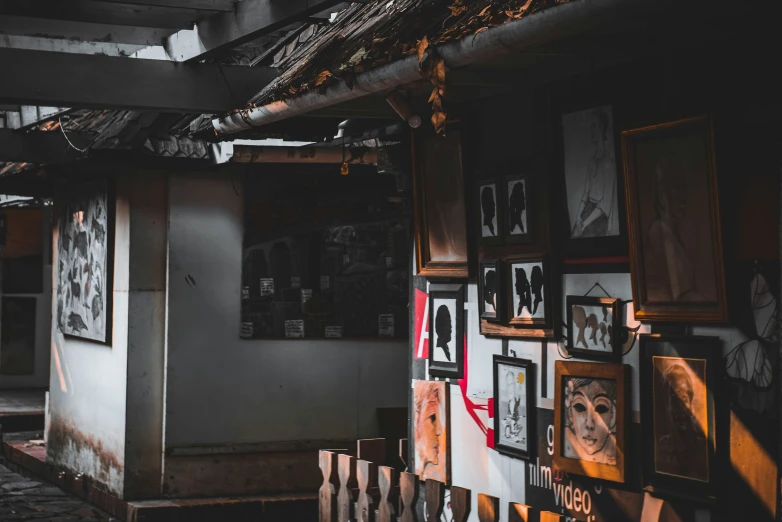 a dark picture with several framed pictures hanging on a fence