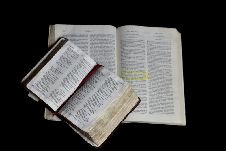 two open old book on the black table