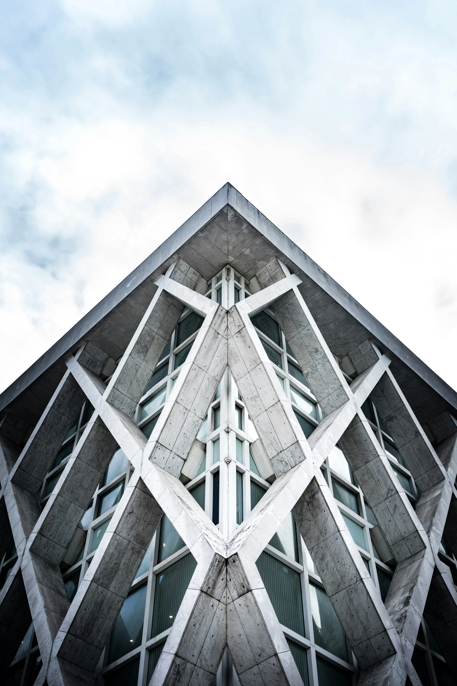 a triangular building with an abstract facade is viewed up high