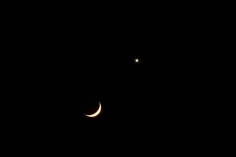 a crescent moon and the crescent of venus in the night sky