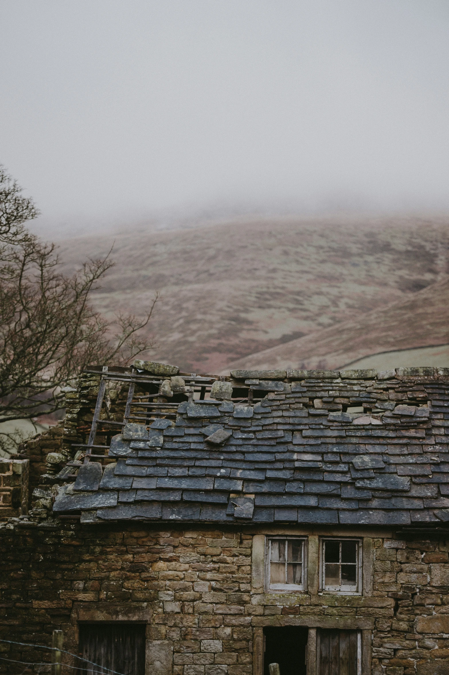 an old brick building with slate roofs on it