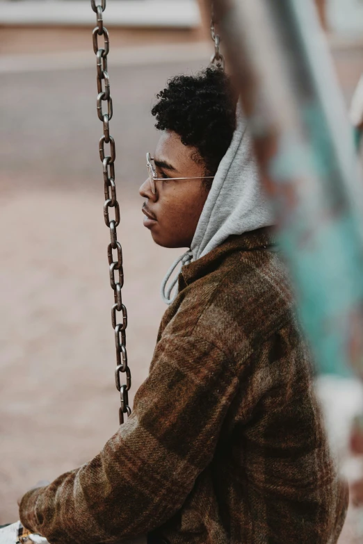 a young man in glasses holds on to a chain