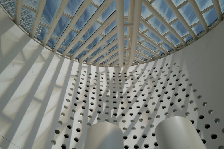 an interior of white plastic structures with lots of perforated metal rods