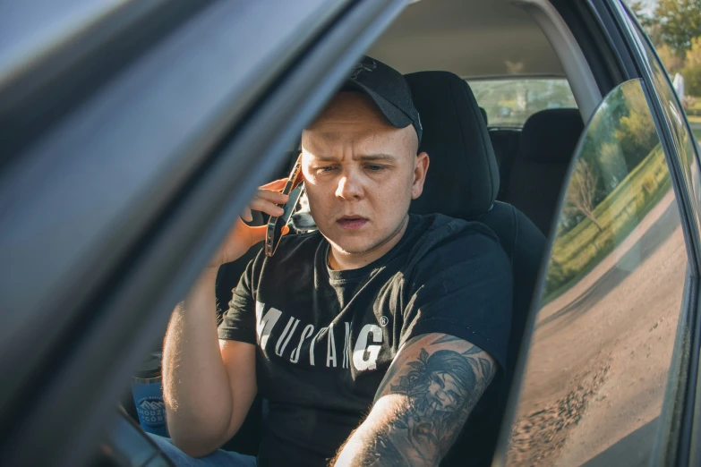 man talking on a cell phone in the back seat of his car