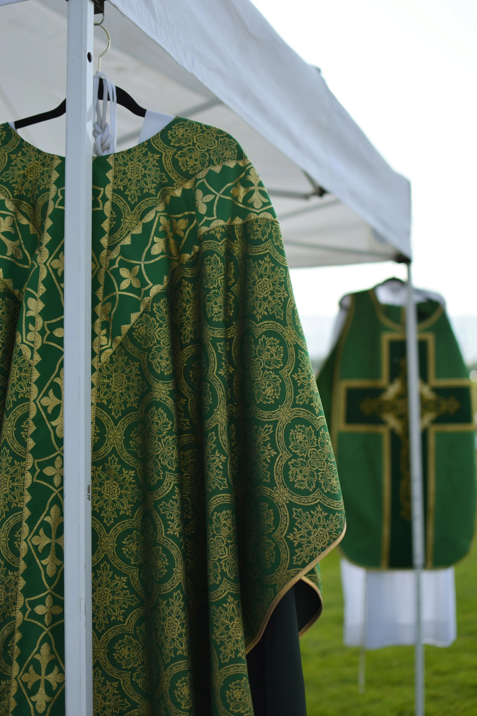 a green and gold religious priest's coat and chair