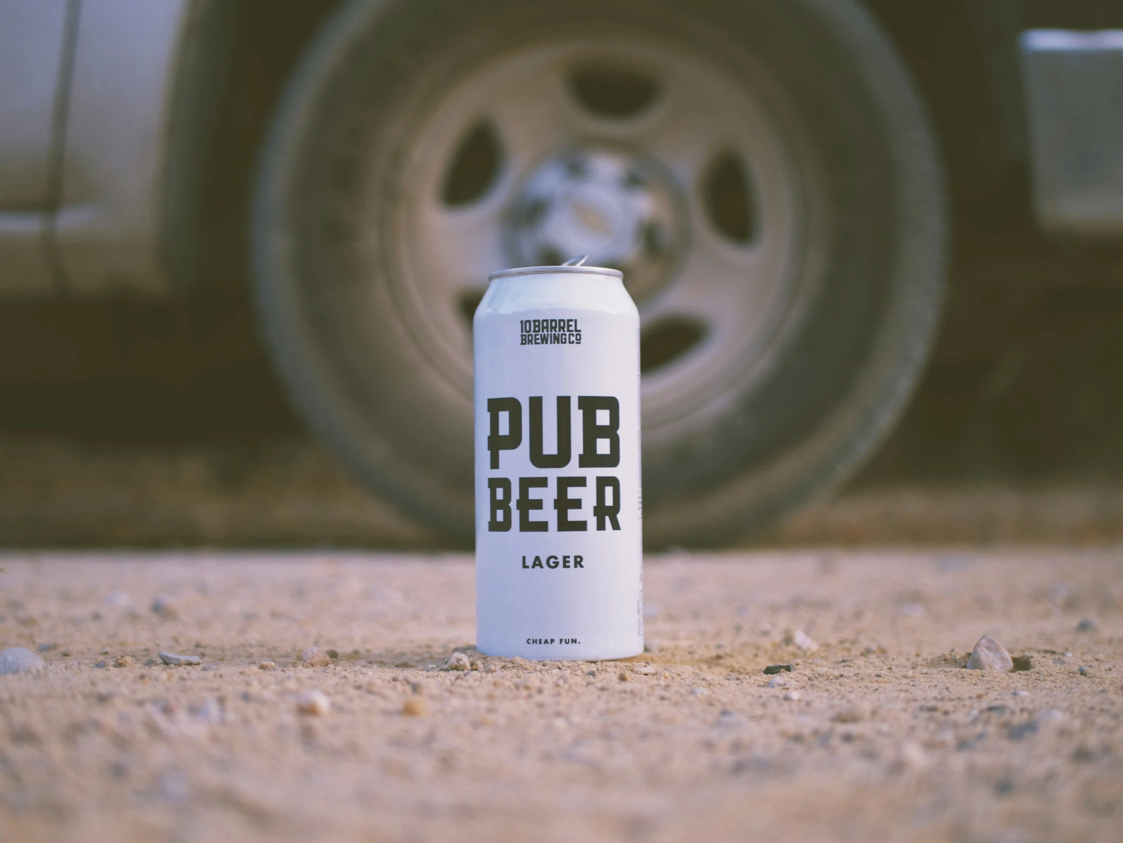 a can sitting on the ground in front of a car