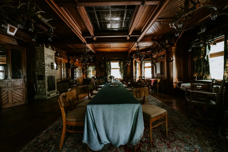 a fancy dining room with tables, chairs and an old fashioned fireplace