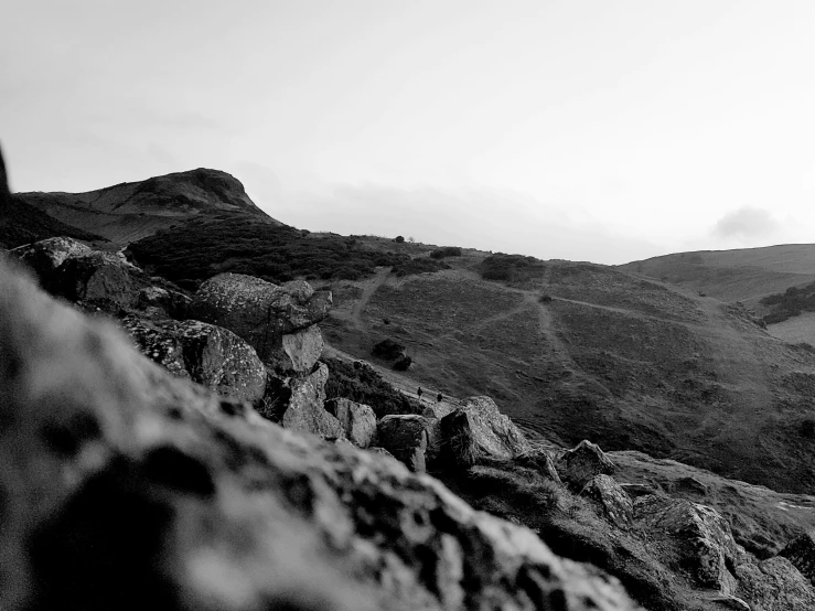 the person is standing on top of the rocks near the mountains