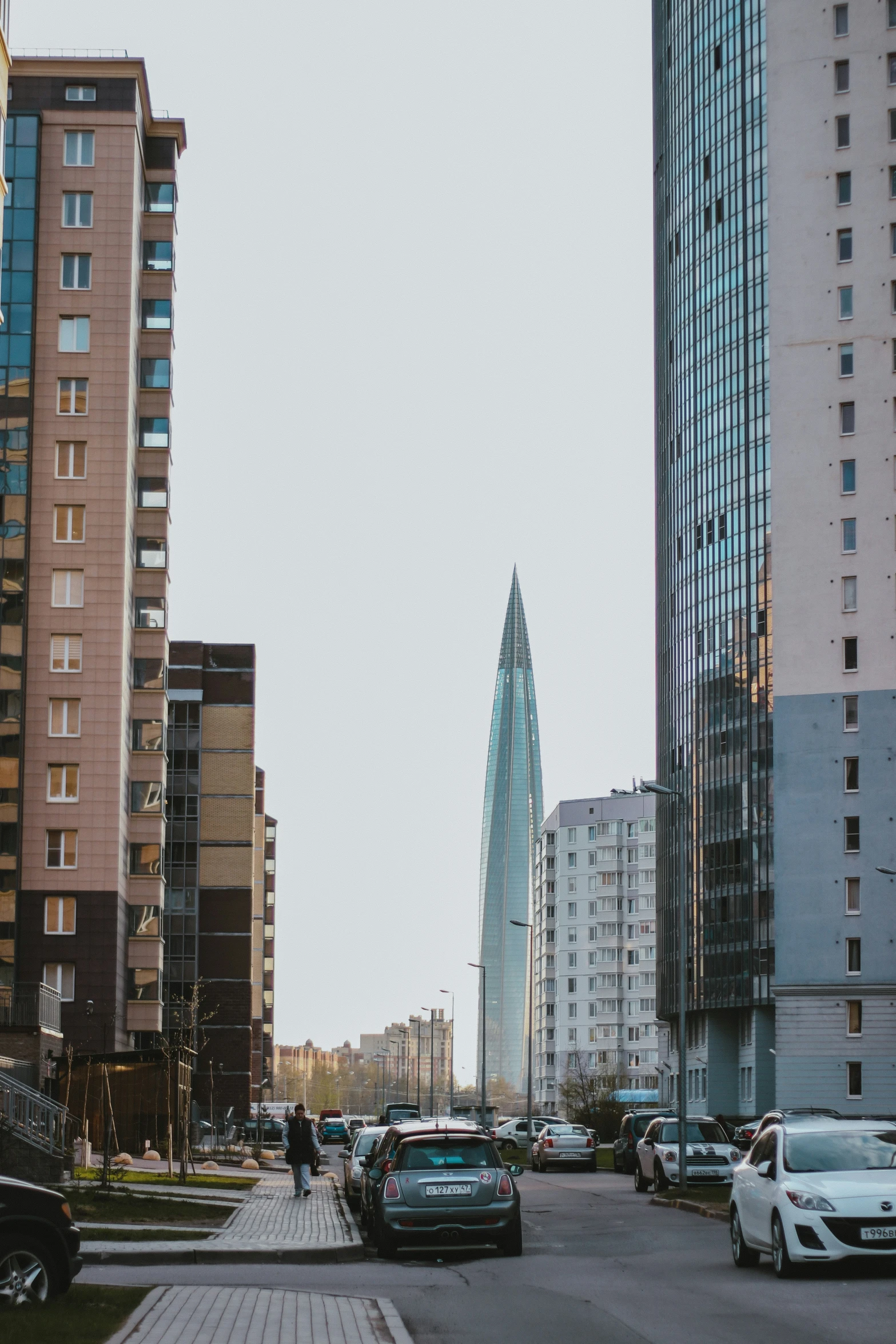 several cars parked on a city street with tall buildings in the background