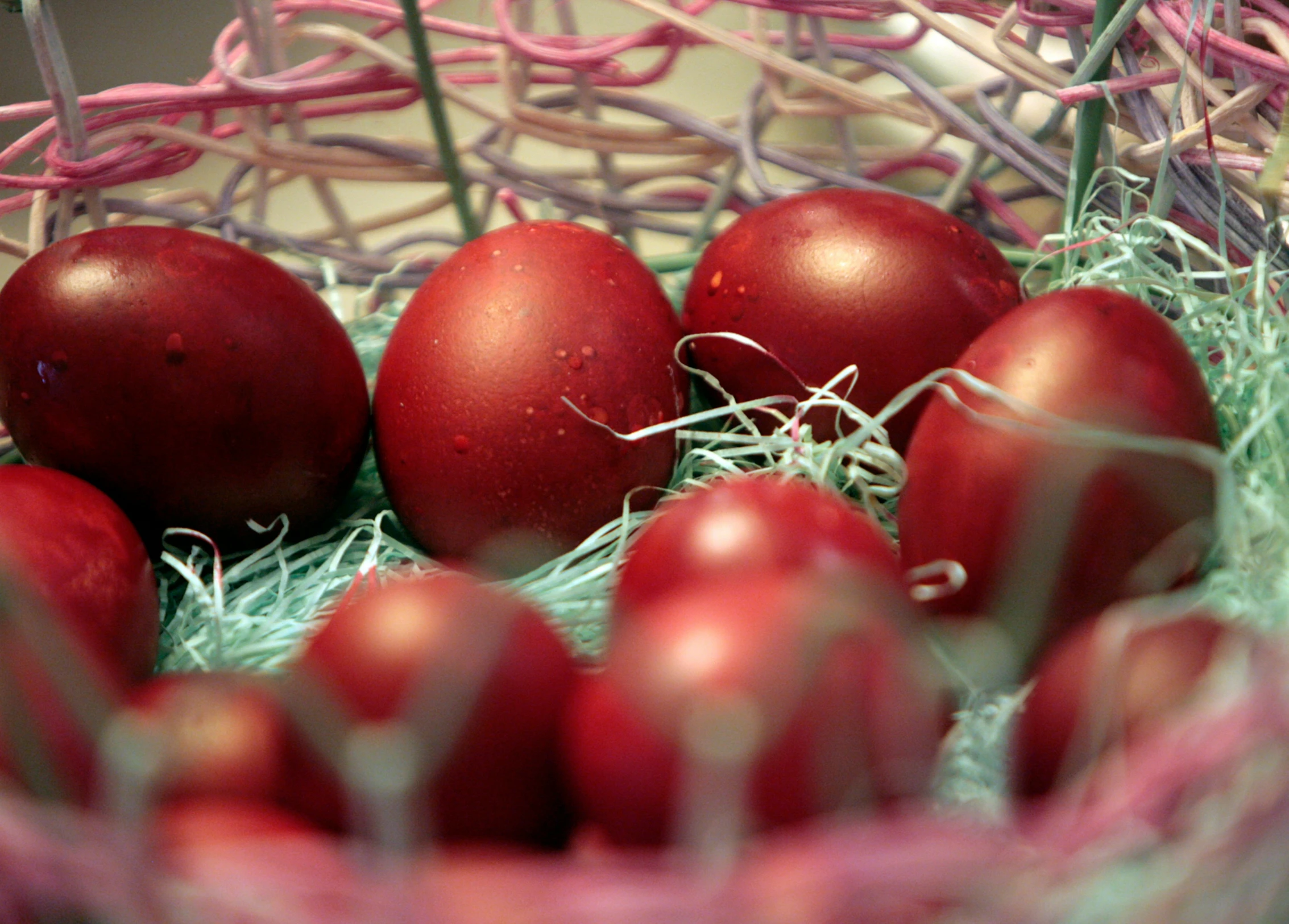 some red eggs are sitting in a bowl