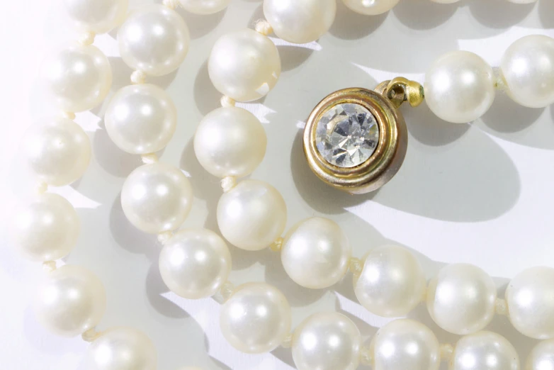 a necklace with pearls and a diamond pendant