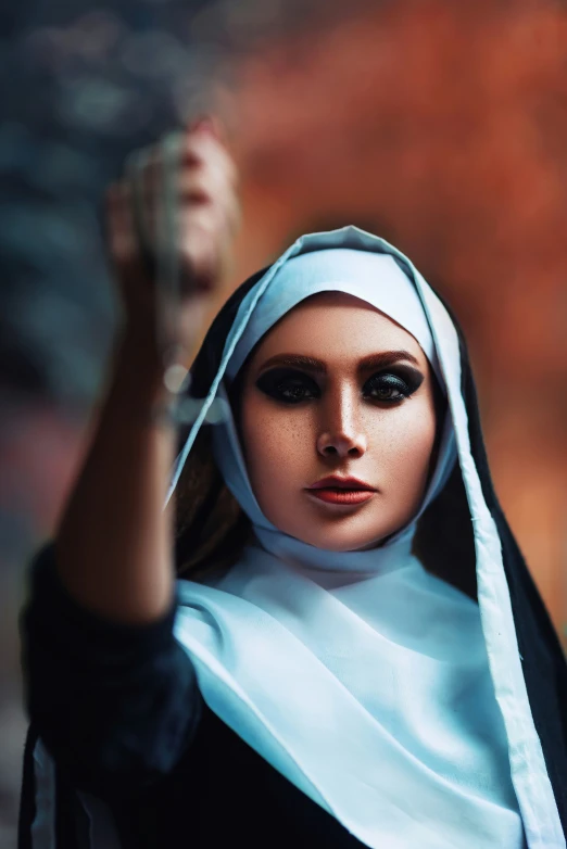 a woman dressed in nun outfit holding her hands up